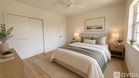 A bedroom with a bed, nightstands, and a plant.