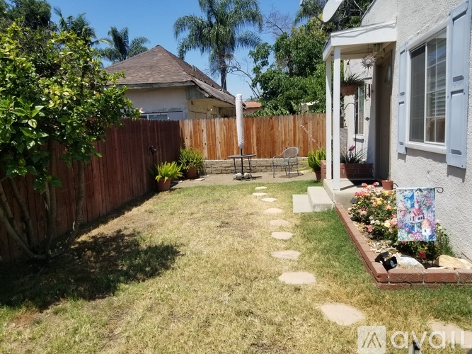 A backyard with a wooden fence and a small garden area.