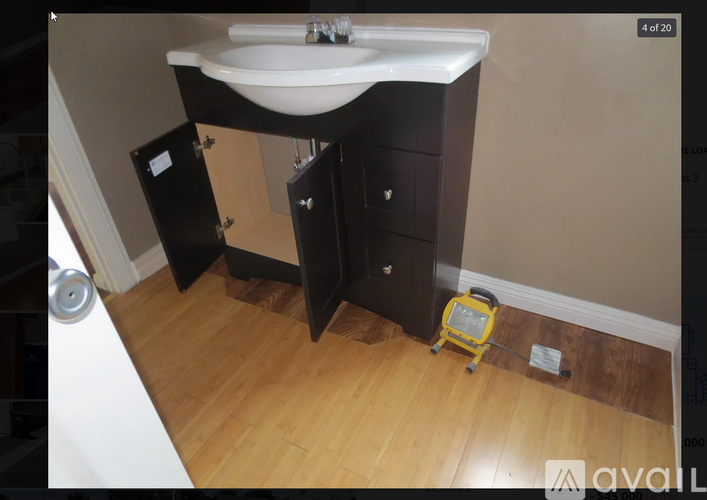 A bathroom with a sink, a cabinet, and a vacuum cleaner.
