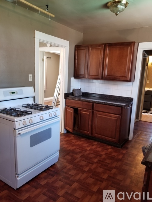 A white gas stove in a kitchen with wooden cabinets.