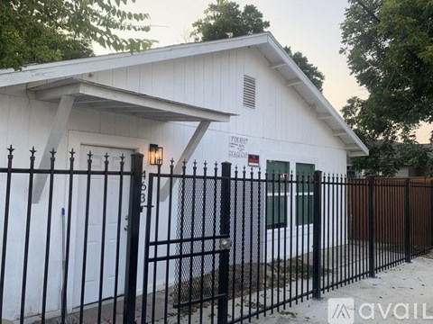 A white building with a black fence in front of it.