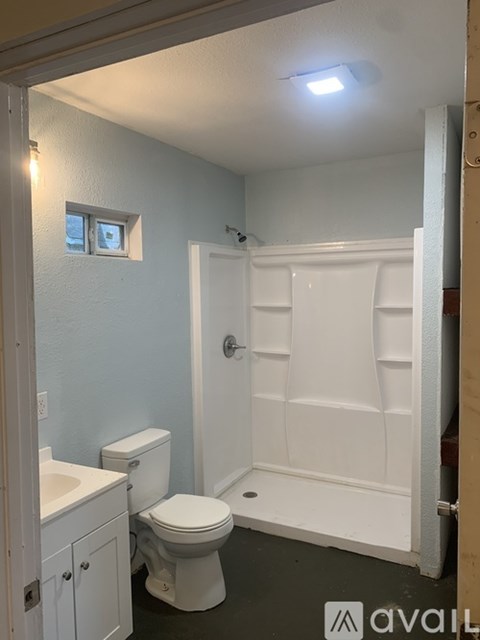A white bathroom with a toilet, sink, and shower.