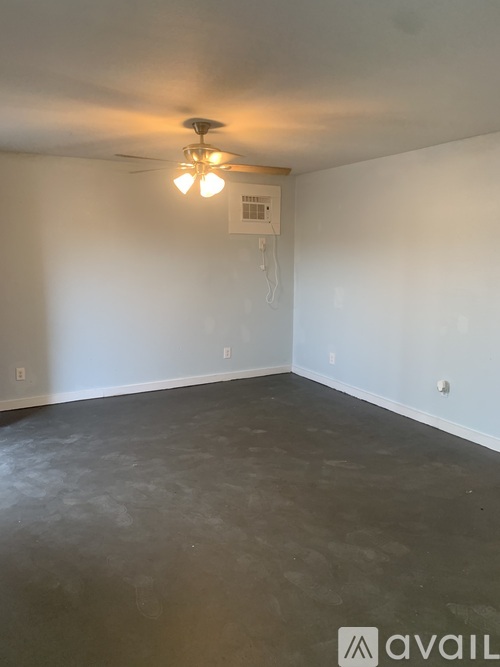A room with a ceiling fan and a basketball hoop on the wall.