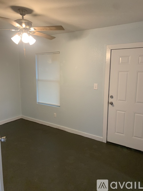 A room with a ceiling fan and a door.