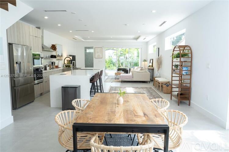 A modern kitchen with a wooden table and chairs.