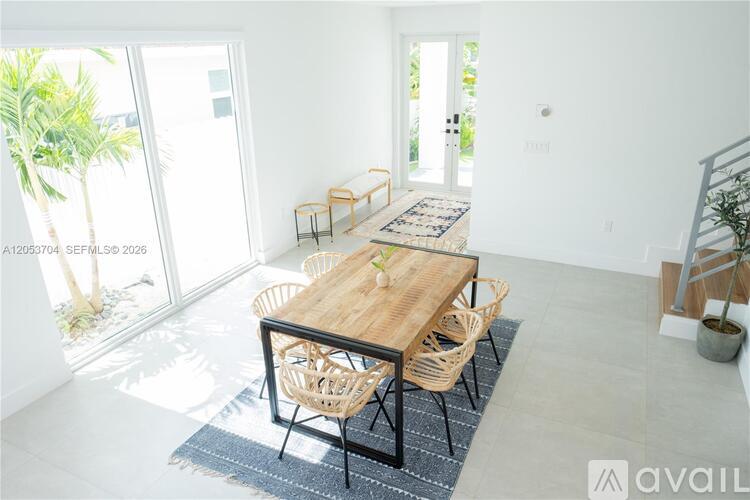 A dining room with a wooden table and chairs.