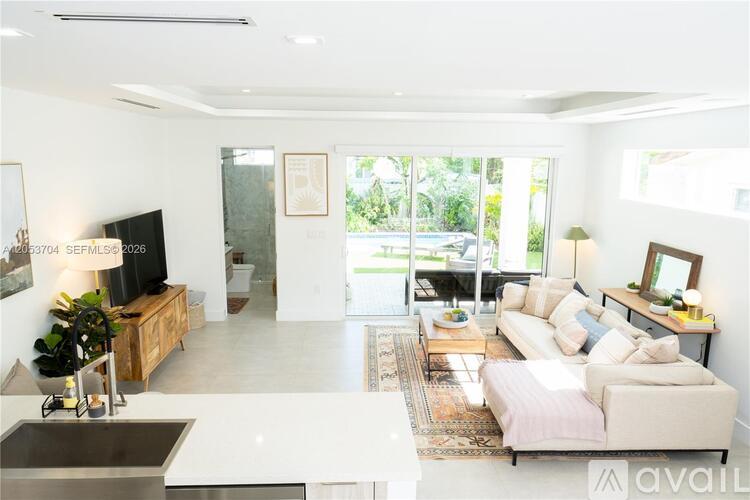 A living room with a white couch and a television.