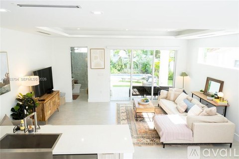 A living room with a white couch and a television.