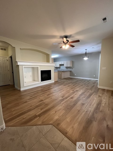A room with wooden flooring and a ceiling fan.