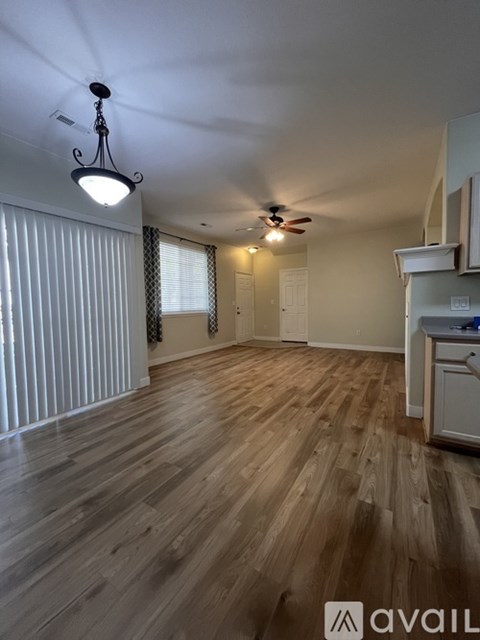 A room with wooden flooring and a ceiling fan.