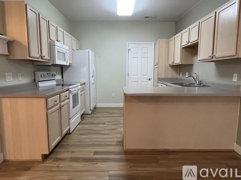 A kitchen with wooden cabinets and a white refrigerator.