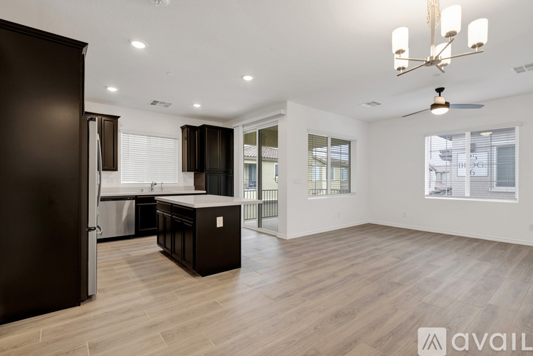 A spacious kitchen with dark brown cabinets and a wooden floor.