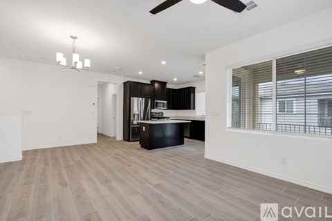 A spacious living room with a ceiling fan and hardwood flooring.