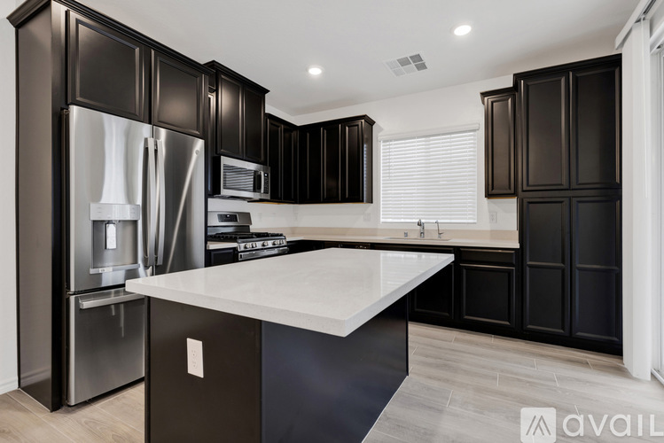 A kitchen with black cabinets and a white countertop.