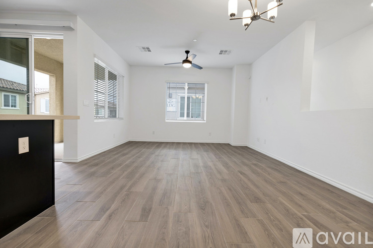 A spacious room with wooden flooring and a ceiling fan.