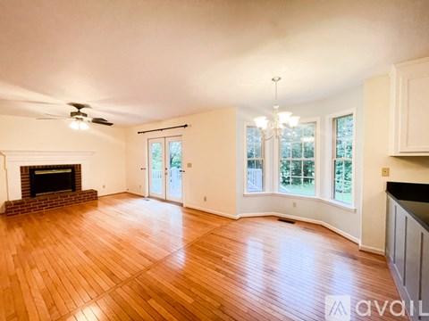 A living room with a fireplace and wood flooring.