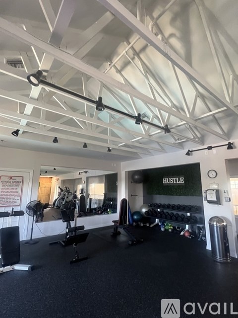A gym with a sign that says "HUSTLE" on the wall.