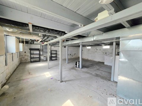 A large, empty industrial space with concrete floors and exposed ceiling beams.