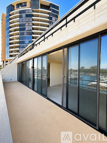 A modern building with a balcony overlooking a body of water.