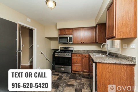 A kitchen with brown cabinets and a black refrigerator is on the market.