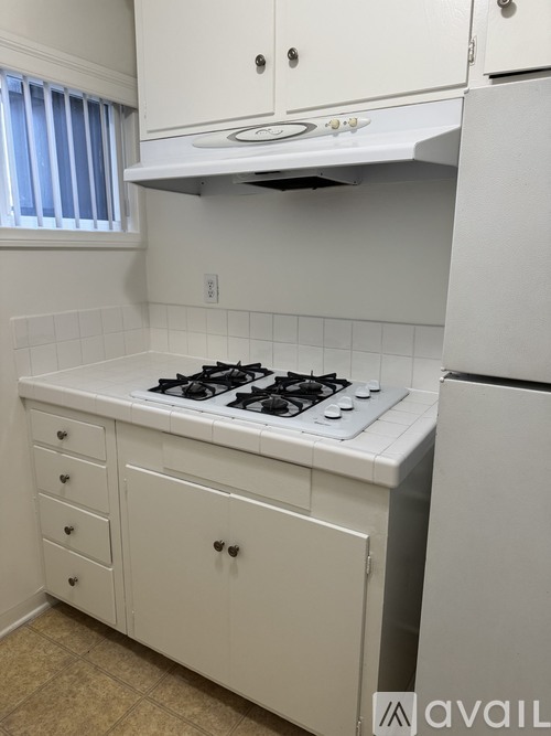 A white kitchen with a stove and cabinets.