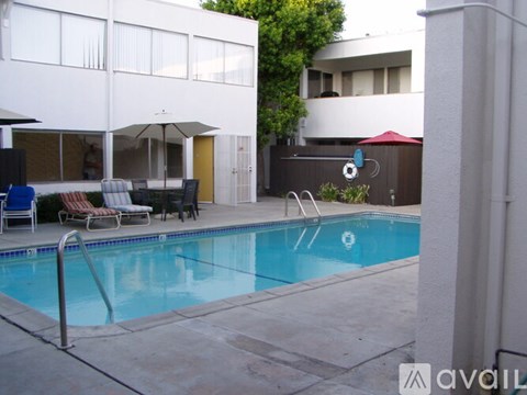 A pool with a diving board and a small waterfall.