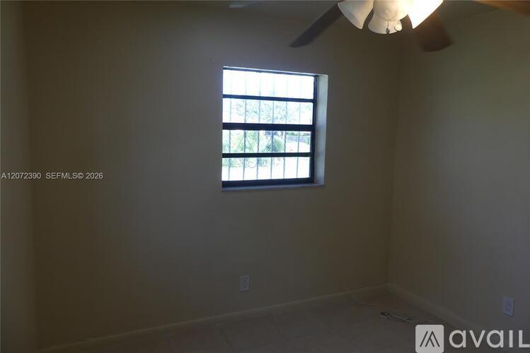 A room with a window and a ceiling fan.