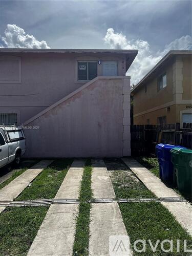 A house with a white car parked in front of it.
