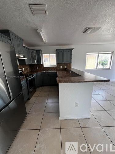 A kitchen with a white island in the middle.