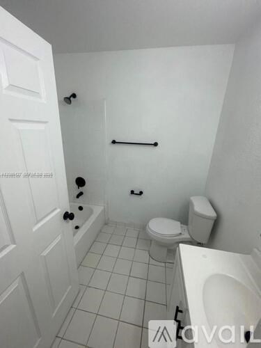 A white bathroom with a toilet, sink, and shower.