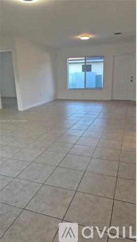 A spacious room with tiled flooring and a window overlooking a cityscape.