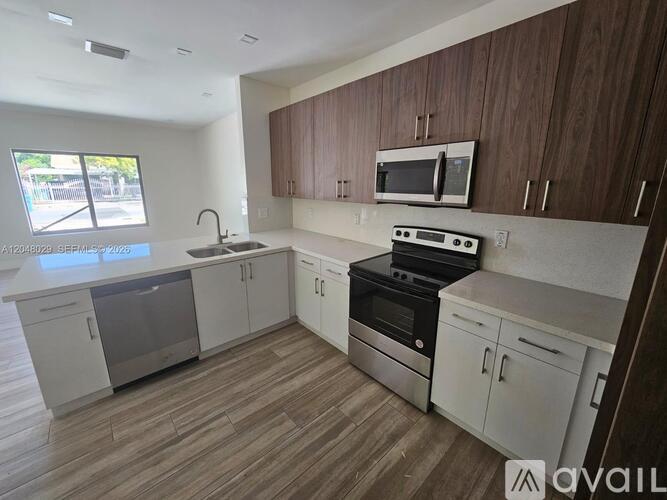 A kitchen with white cabinets and a wooden backsplash.
