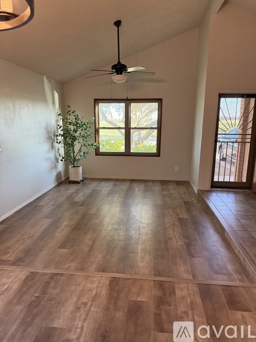 A room with wooden flooring and a ceiling fan.