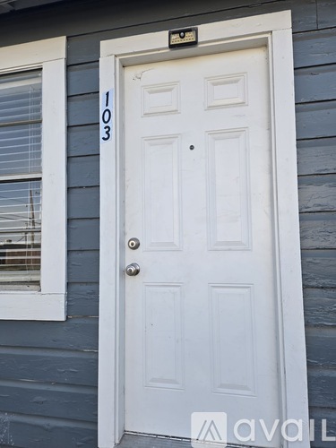 A white door with a black mailbox on the side of a house.