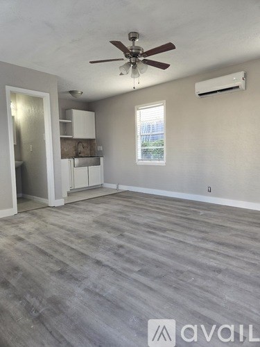 A room with a ceiling fan and a window.
