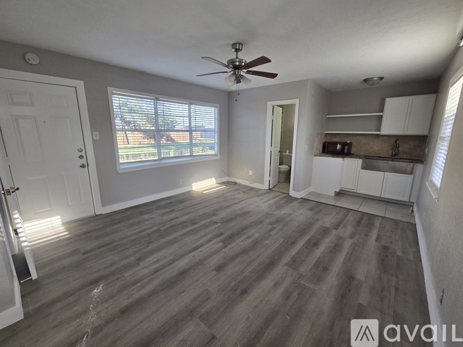 A room with a ceiling fan and wooden flooring.