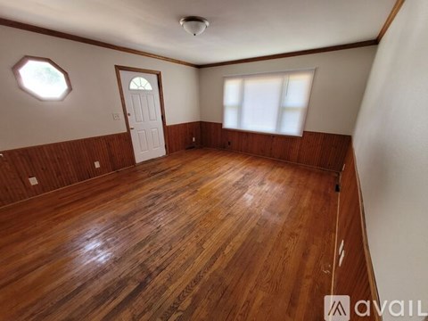 A room with wooden flooring and a white door.