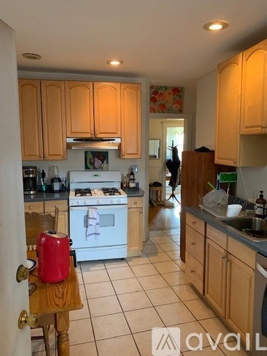 A kitchen with wooden cabinets and a white stove.