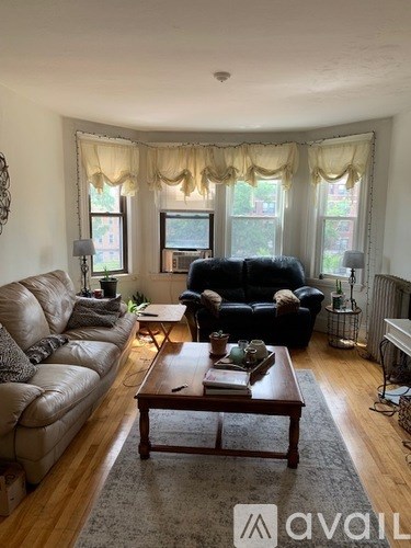 A living room with a brown leather couch and a wooden coffee table.