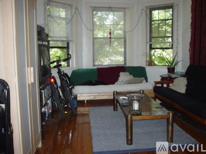 A living room with a couch, a chair, a coffee table, and a bicycle.
