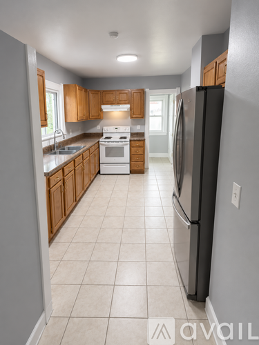 A kitchen with a black refrigerator and wooden cabinets.