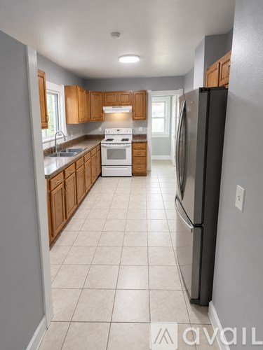 A kitchen with a black refrigerator and wooden cabinets.