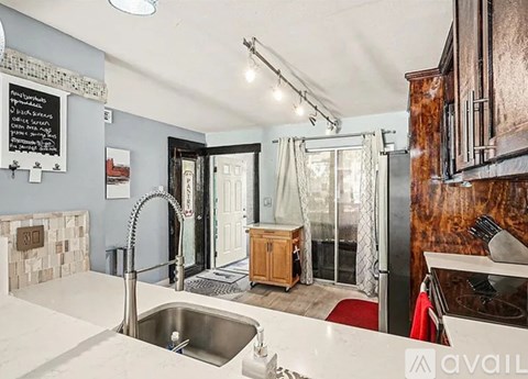 A kitchen with a sink and a chalkboard on the wall.