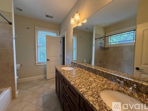 A bathroom with a granite countertop and a large mirror.