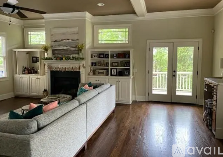 A living room with a grey couch and a fireplace.