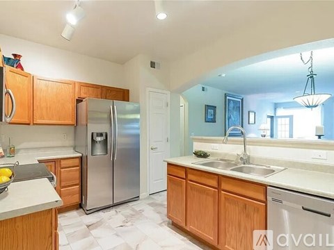 A kitchen with wooden cabinets and a stainless steel refrigerator.