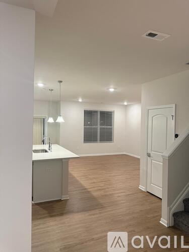 A white kitchen with a sink and a window.