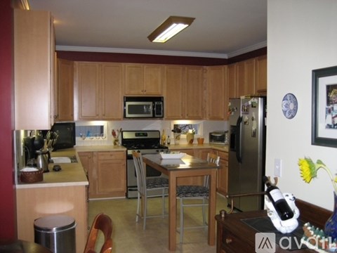 A kitchen with wooden cabinets and a refrigerator.