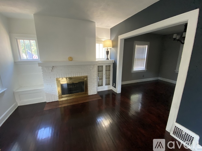 A living room with a fireplace and a lamp.
