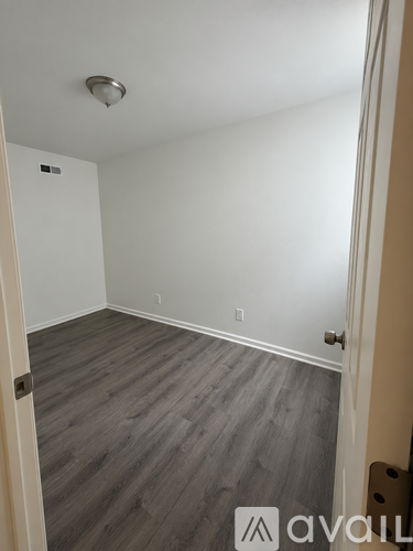 A room with a wooden floor and a white door.